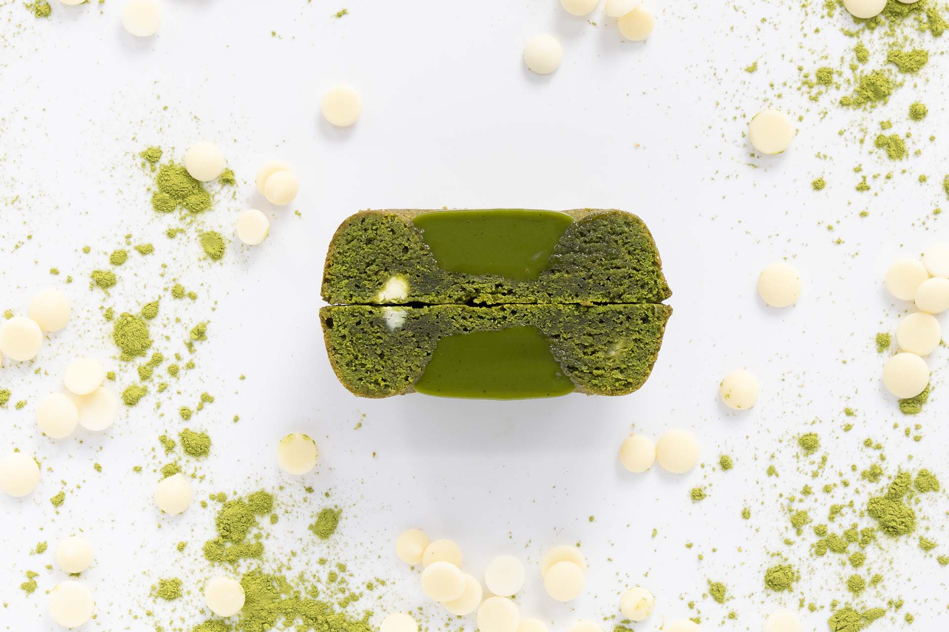 Matcha flavored dessert with white chocolate chips and espresso powder garnish on a white background.