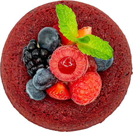 Top view of a red velvet cake topped with assorted fresh berries and a sprig of mint, perfect for the Homepage.